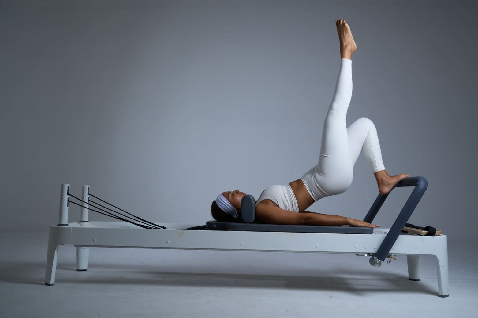 Persona haciendo pilates en reformer.