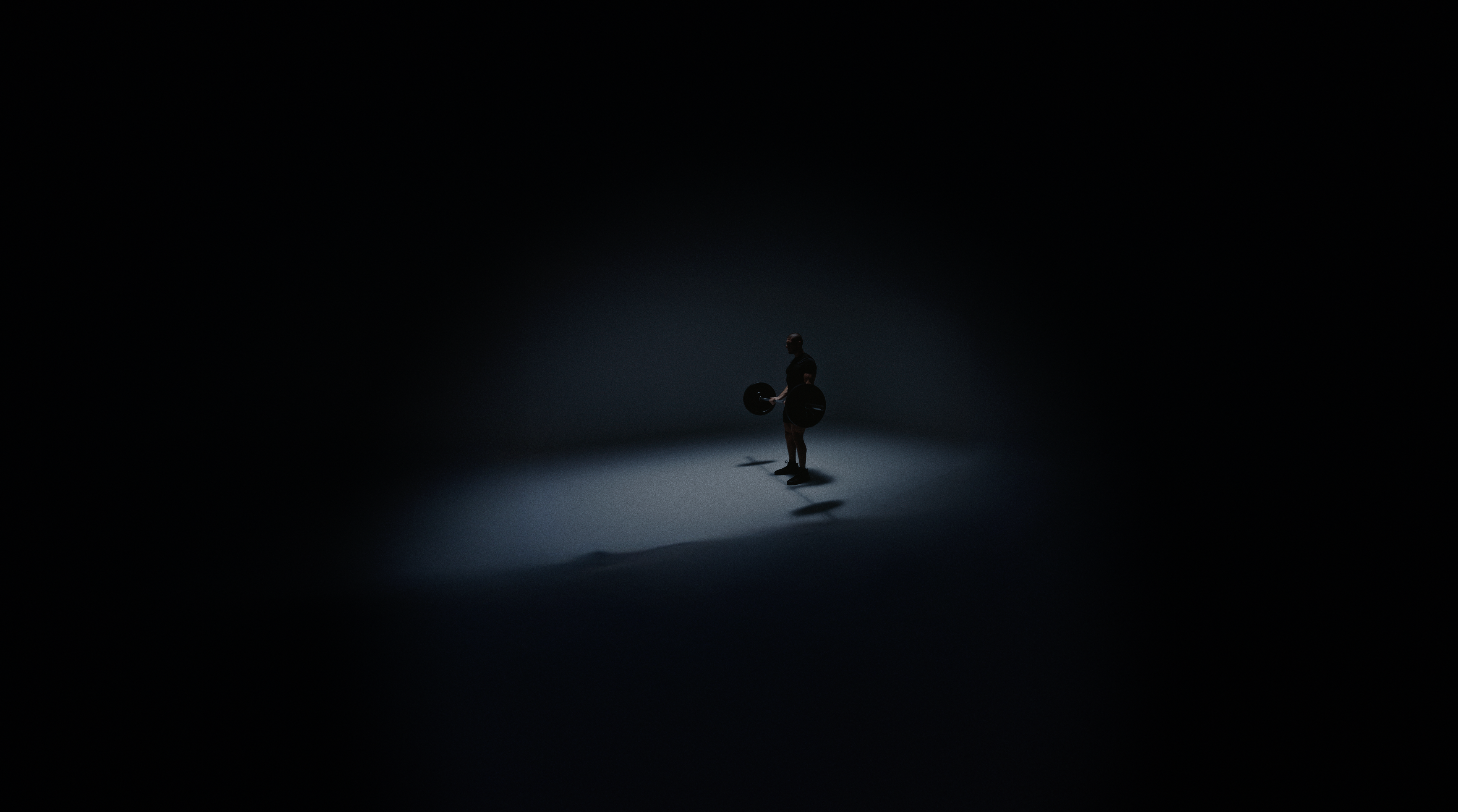 Persona entrenando bajo una luz puntual en un estudio oscuro.